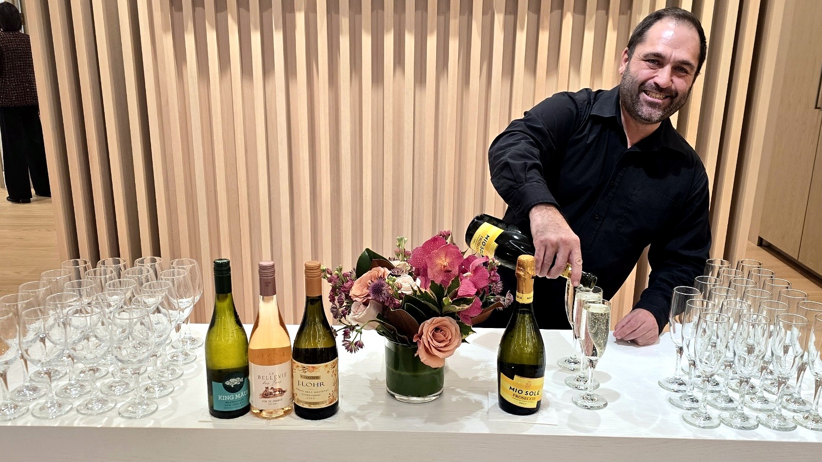 Bartender pouring champagne at a prepared event bar